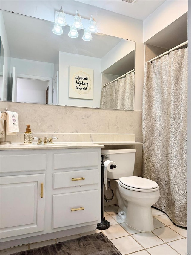 bathroom featuring vanity, toilet, tile patterned flooring, and decorative backsplash