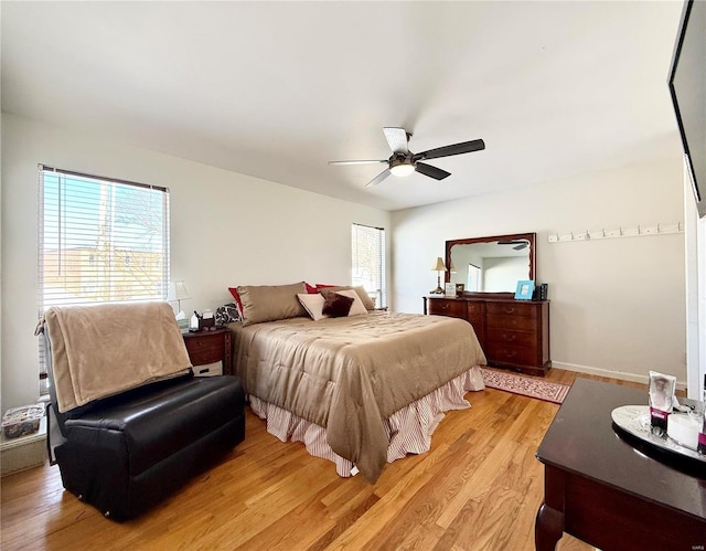 bedroom with ceiling fan, multiple windows, and light wood-type flooring