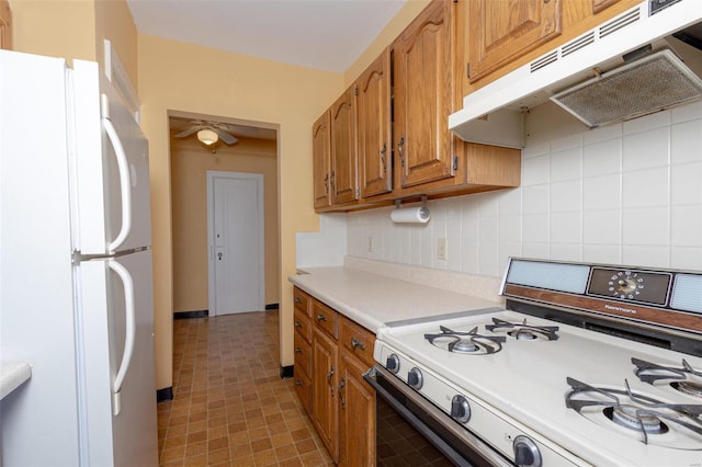 kitchen with white appliances, ceiling fan, and tasteful backsplash