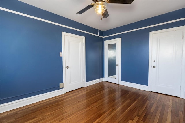 unfurnished room featuring dark wood-type flooring and ceiling fan