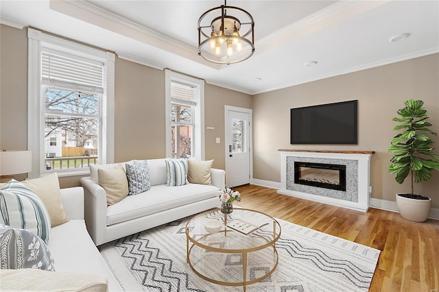 living room with crown molding, light hardwood / wood-style floors, and an inviting chandelier