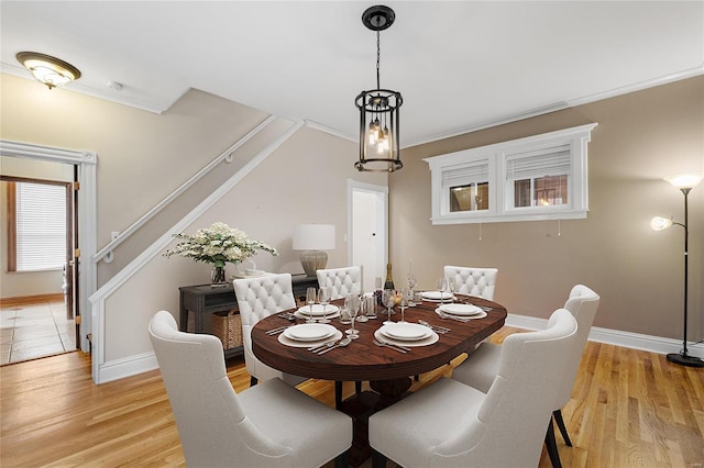 dining area featuring crown molding and light hardwood / wood-style floors