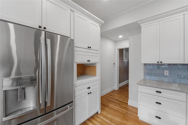 kitchen featuring white cabinetry, stainless steel fridge, tasteful backsplash, and light hardwood / wood-style flooring