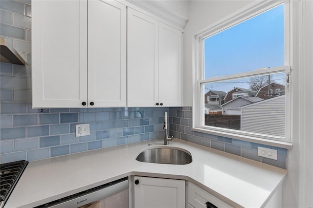 kitchen with tasteful backsplash, cooktop, sink, dishwasher, and white cabinetry