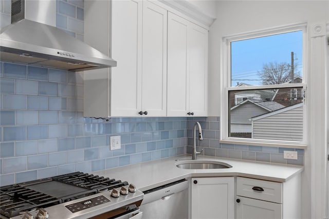 kitchen featuring sink, tasteful backsplash, white cabinetry, and wall chimney range hood