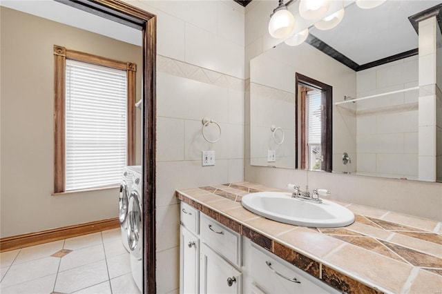 bathroom featuring tile patterned flooring, vanity, independent washer and dryer, and walk in shower