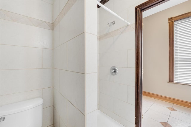 bathroom featuring tiled shower and toilet