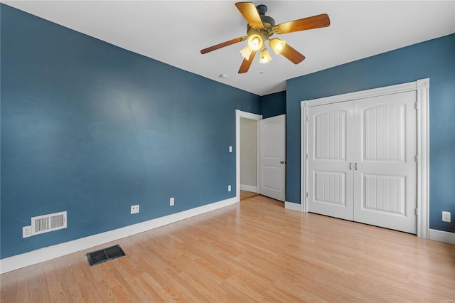 unfurnished bedroom featuring ceiling fan, light wood-type flooring, and a closet