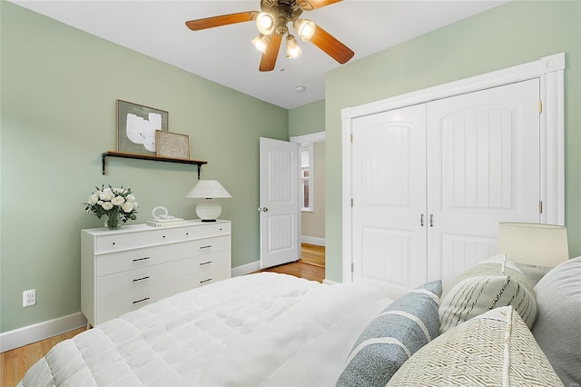 bedroom with ceiling fan, a closet, and light hardwood / wood-style floors