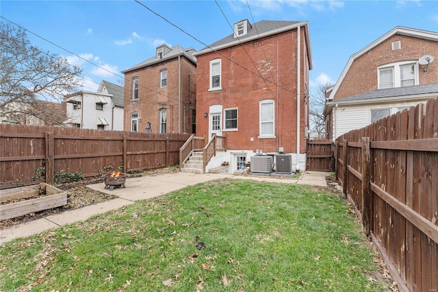 rear view of property with a yard and central AC unit