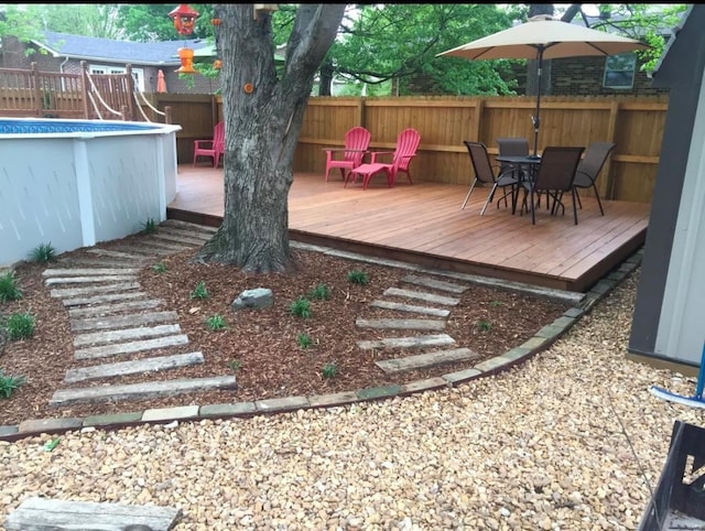 wooden deck with a fenced in pool