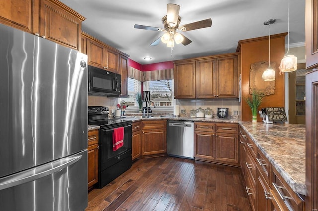 kitchen with pendant lighting, dark wood-type flooring, black appliances, ceiling fan, and light stone countertops