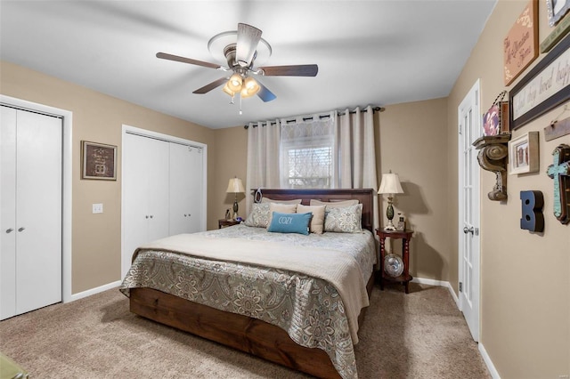 carpeted bedroom featuring ceiling fan and two closets