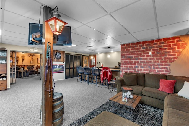 living room with carpet flooring, a paneled ceiling, and indoor bar