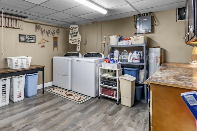 laundry area with washer and clothes dryer, electric panel, and hardwood / wood-style floors