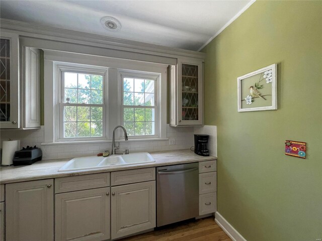 kitchen featuring stainless steel dishwasher, white cabinetry, sink, and tasteful backsplash