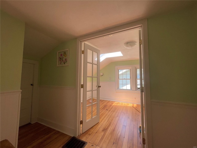 hallway featuring light hardwood / wood-style floors and lofted ceiling