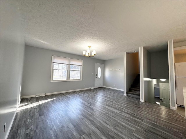 unfurnished living room featuring a textured ceiling, dark hardwood / wood-style floors, and a notable chandelier