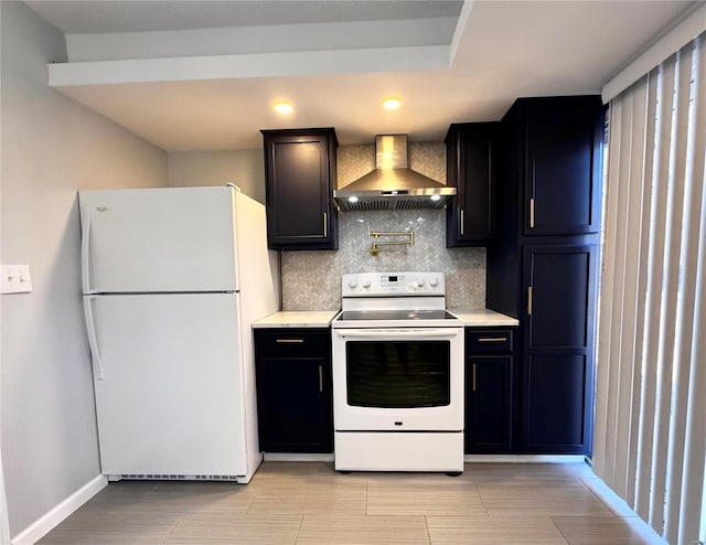 kitchen with backsplash, wall chimney exhaust hood, and white appliances