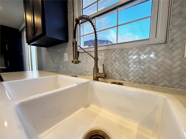 details featuring tasteful backsplash and sink