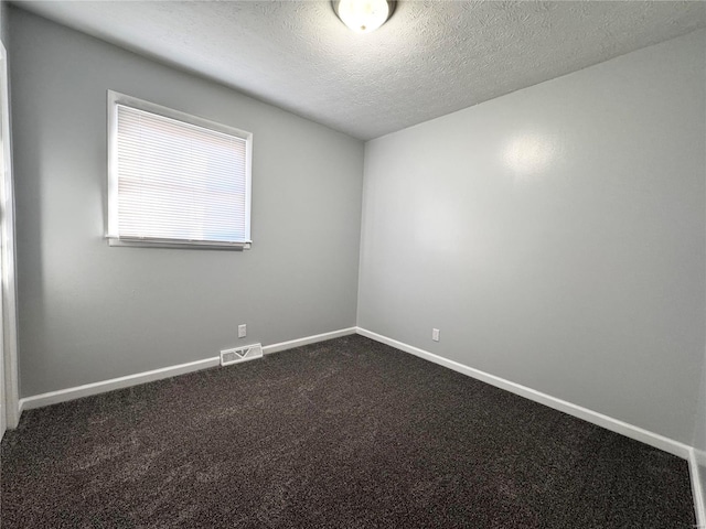 carpeted spare room with a textured ceiling