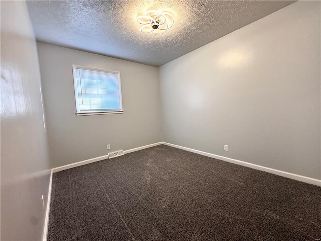 empty room with carpet flooring and a textured ceiling