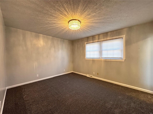 empty room featuring carpet flooring and a textured ceiling