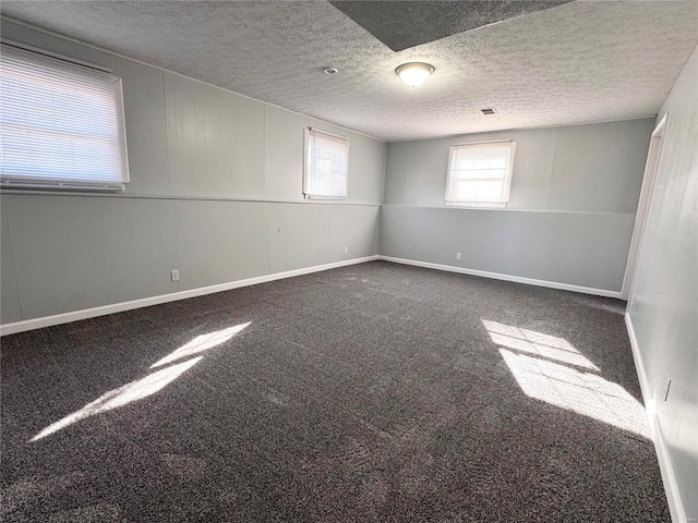 carpeted spare room featuring a textured ceiling