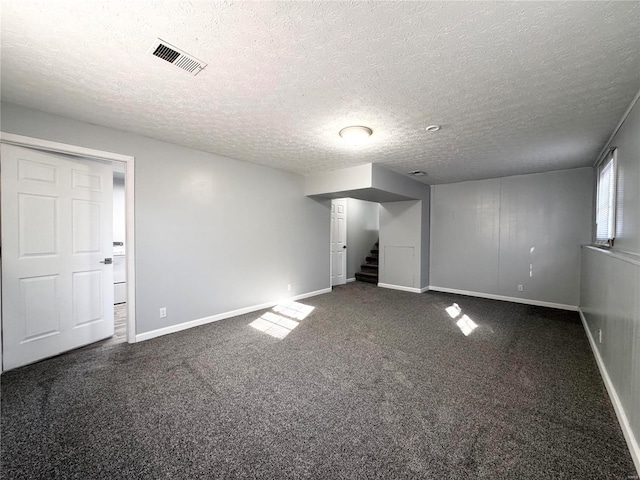 carpeted empty room with a textured ceiling