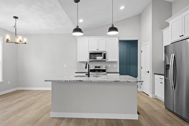 kitchen featuring white cabinetry, hanging light fixtures, an island with sink, and stainless steel appliances