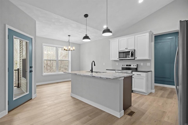 kitchen with white cabinets, pendant lighting, sink, and stainless steel appliances