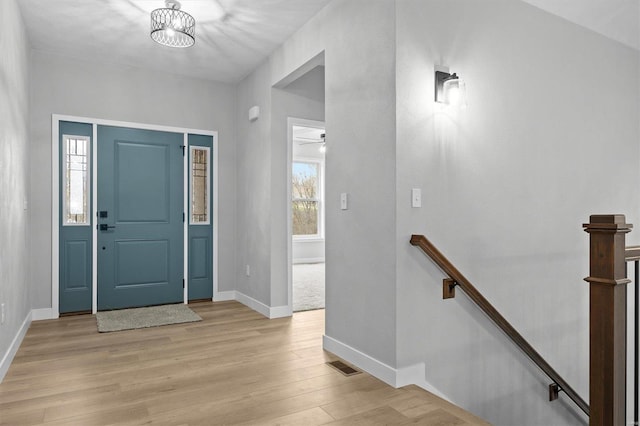 entrance foyer with a notable chandelier and light hardwood / wood-style flooring