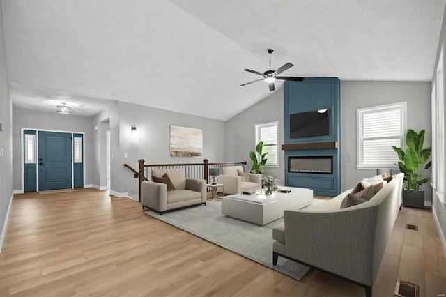 living room with light wood-type flooring, vaulted ceiling, and ceiling fan