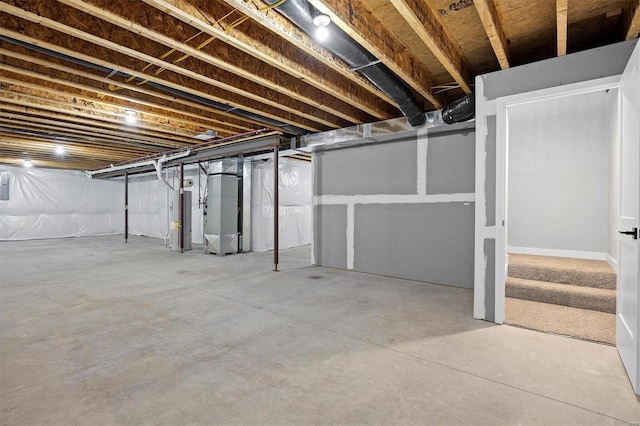 basement featuring heating unit and electric water heater