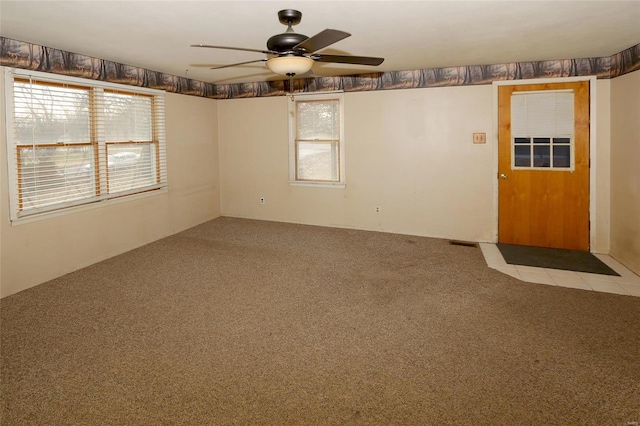 spare room featuring light colored carpet and ceiling fan