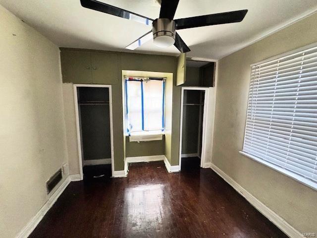 unfurnished bedroom featuring ceiling fan, dark hardwood / wood-style flooring, and a closet