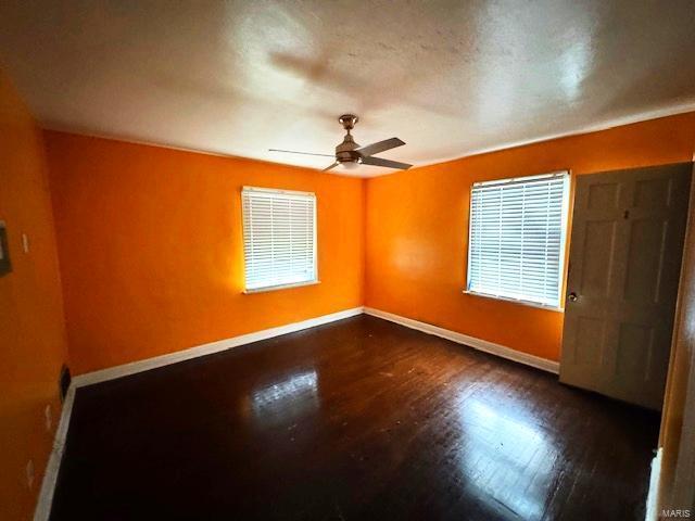 empty room featuring ceiling fan and dark wood-type flooring