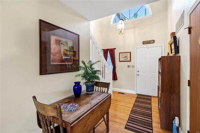 entryway with light hardwood / wood-style flooring and lofted ceiling