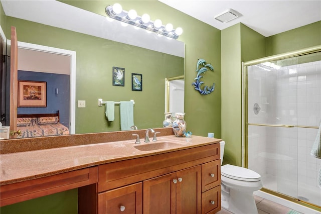 bathroom with tile patterned floors, vanity, toilet, and a shower with door