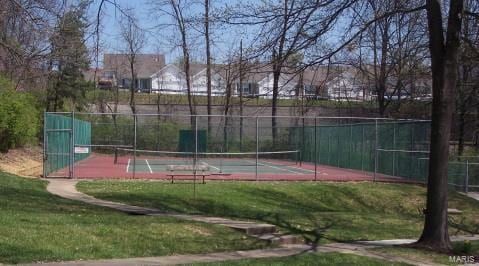 view of tennis court featuring a yard