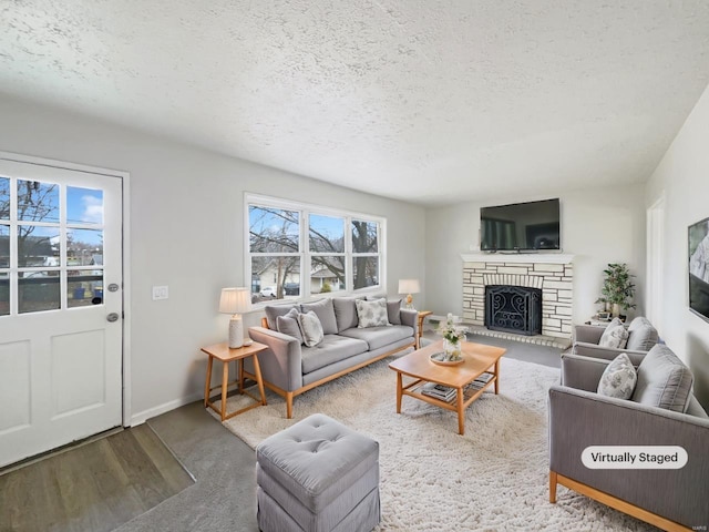 living room featuring a stone fireplace and a textured ceiling