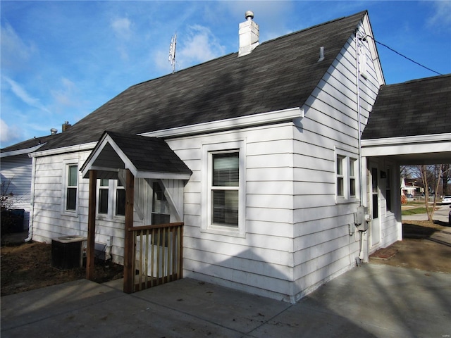 view of front facade featuring central AC and a carport