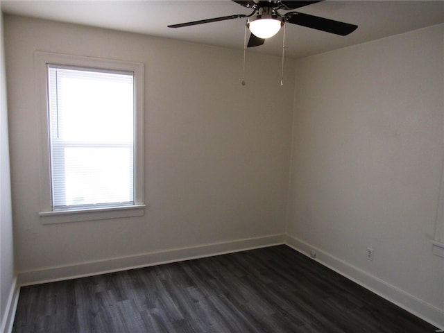 empty room featuring ceiling fan, dark wood-type flooring, and a healthy amount of sunlight