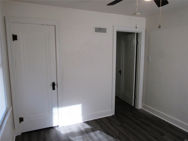 unfurnished bedroom with dark hardwood / wood-style flooring and ceiling fan