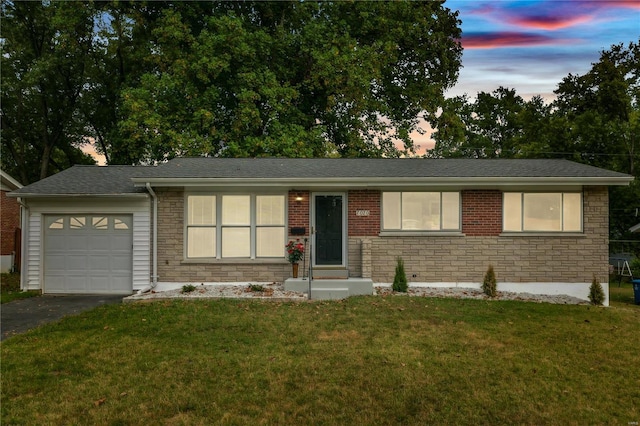 ranch-style home with a yard and a garage