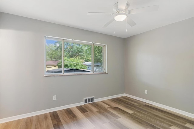 empty room with hardwood / wood-style floors and ceiling fan