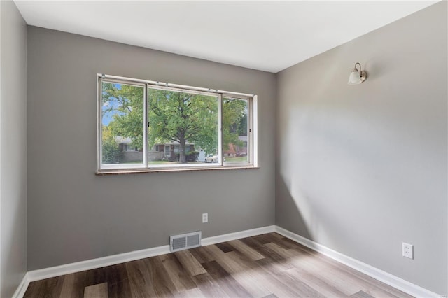 unfurnished room with hardwood / wood-style flooring