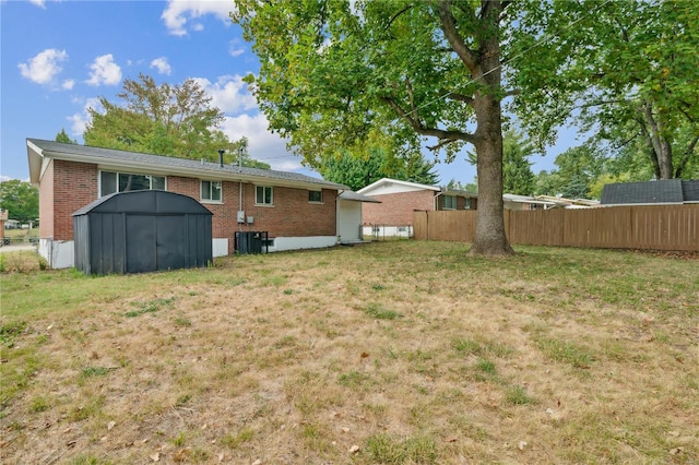 view of yard with central AC and a storage shed