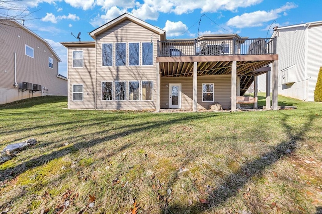 rear view of property featuring a wooden deck and a yard