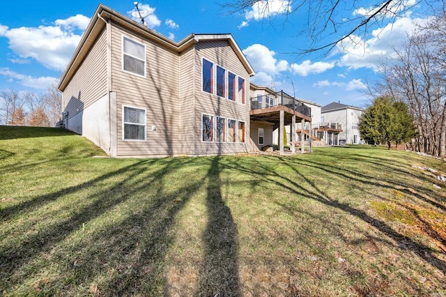 rear view of house featuring a wooden deck and a yard